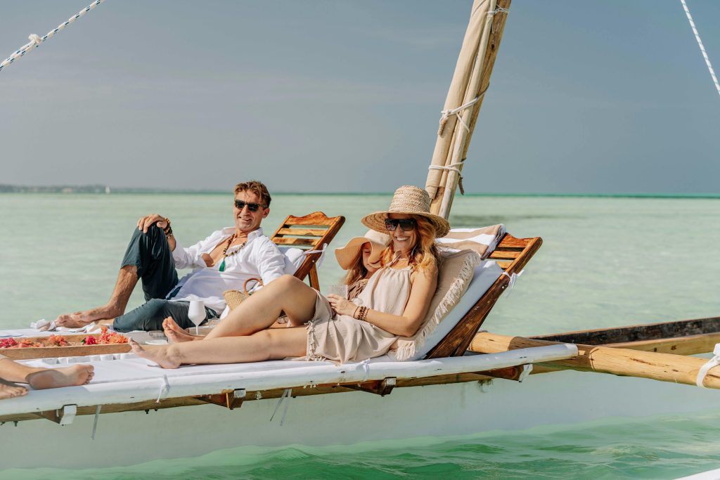 Couple enjoying a relaxing vacation on a dhow in the clear waters of Zanzibar.