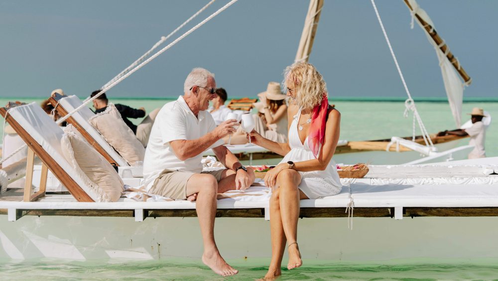 Elderly couple enjoying a serene boat ride on the turquoise waters of Zanzibar.
