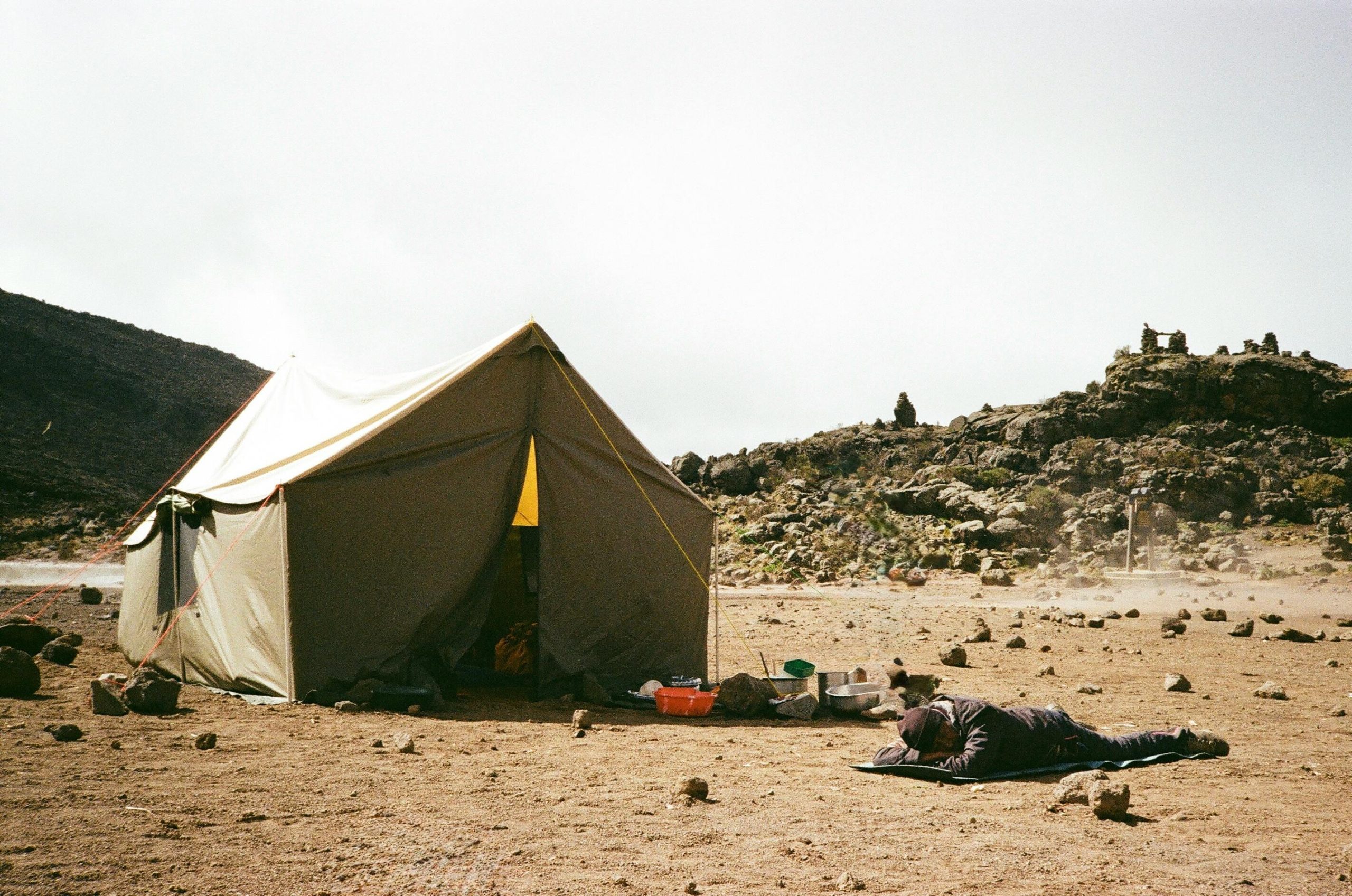 Trekking with Purpose Tent setup amidst rocky terrain at Mount Kilimanjaro, Tanzania. Perfect for adventurers.