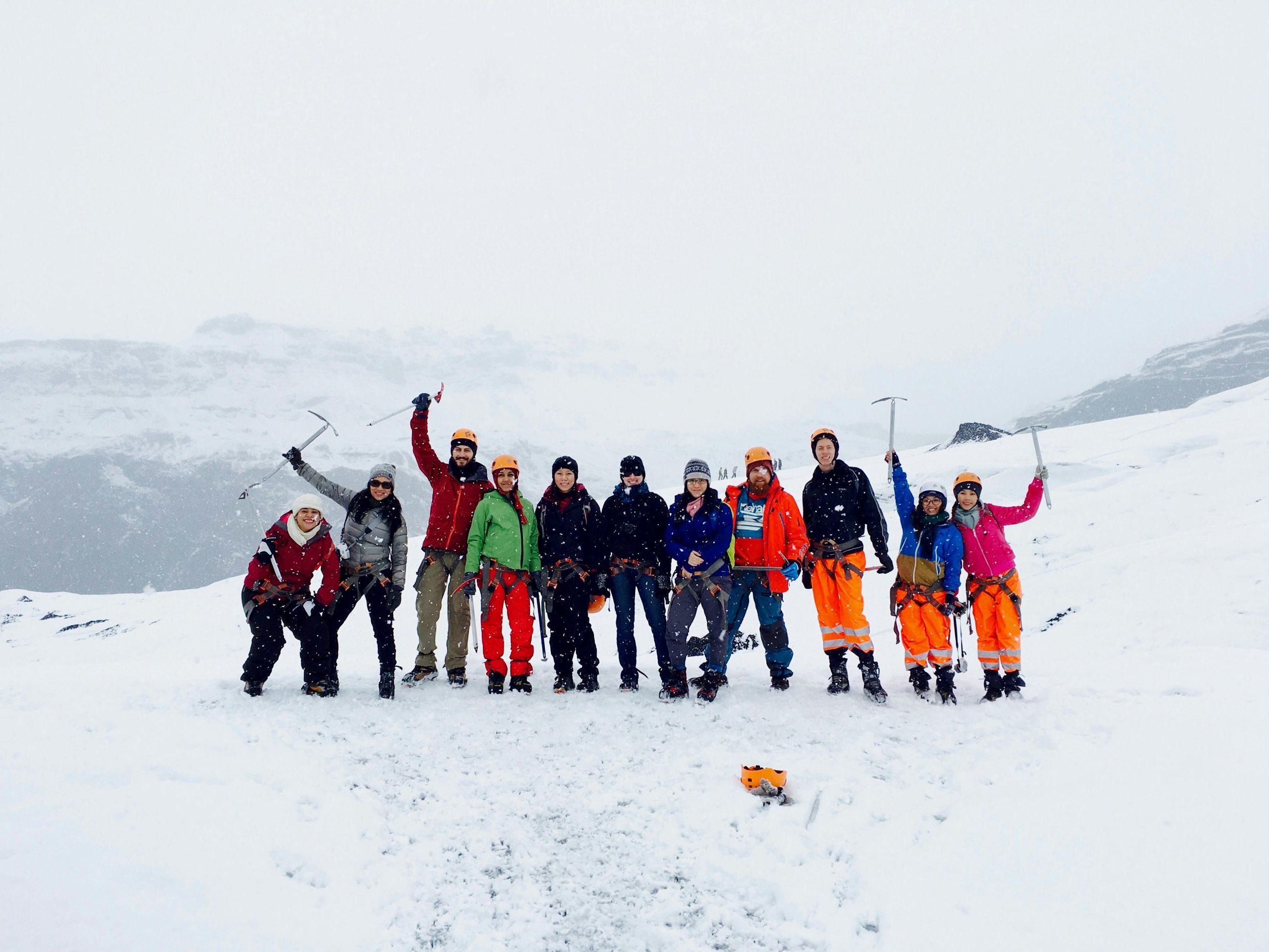 A group of climbers stand proudly on a snowy mountain, showcasing their adventure in winter landscapes.