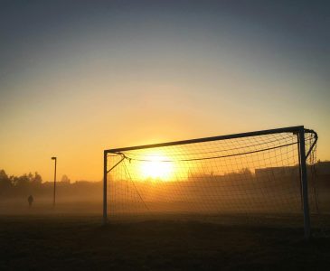 Soccer goal silhouetted against a misty sunrise in a tranquil Mississauga field.